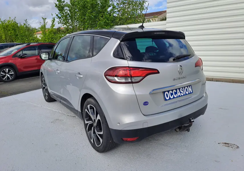 Renault Scénic IV gris platine avec toit noir, vue 3/4 arrière droit, feux arrière et attelage visibles.