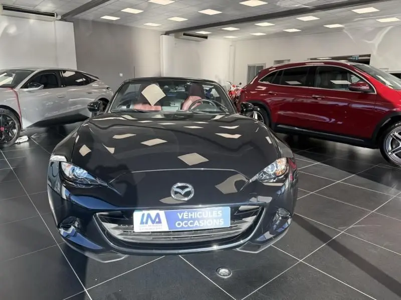 Vue avant d'une Mazda MX-5 noire 2020 en version Eunos Edition, exposée en showroom avec sièges rouges visibles.