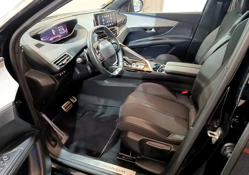 Intérieur noir du Peugeot 3008 GT 2023, vue côté conducteur, volant cuir et tableau de bord digital lumineux.