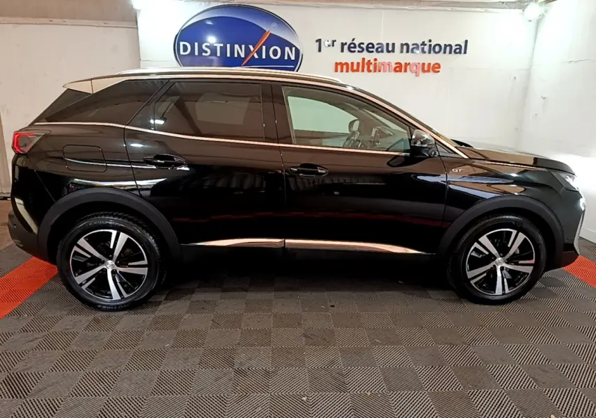 Profil côté gauche d'un Peugeot 3008 GT noir 2023 dans un showroom avec jantes alliage bicolores.