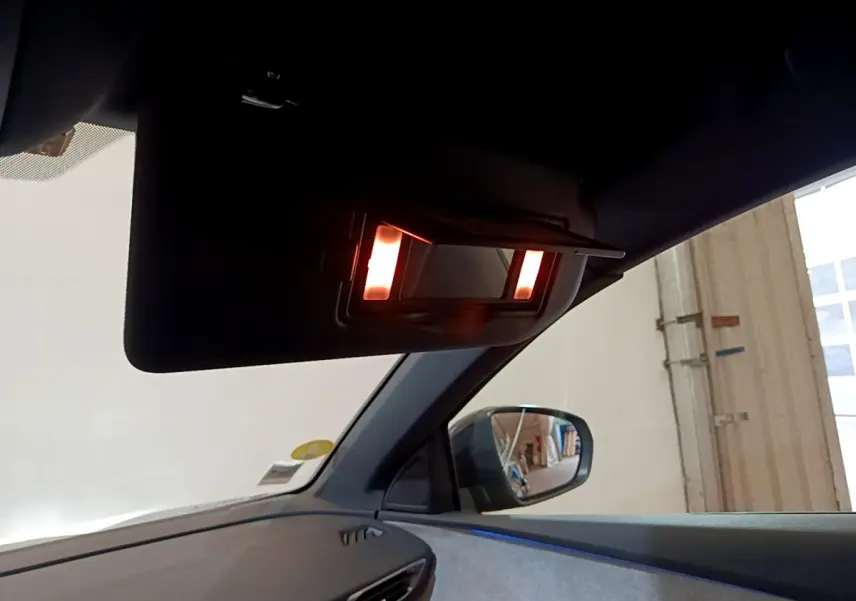 Détail du miroir de courtoisie éclairé sur le pare-soleil côté conducteur du Peugeot 3008 noir 2023.