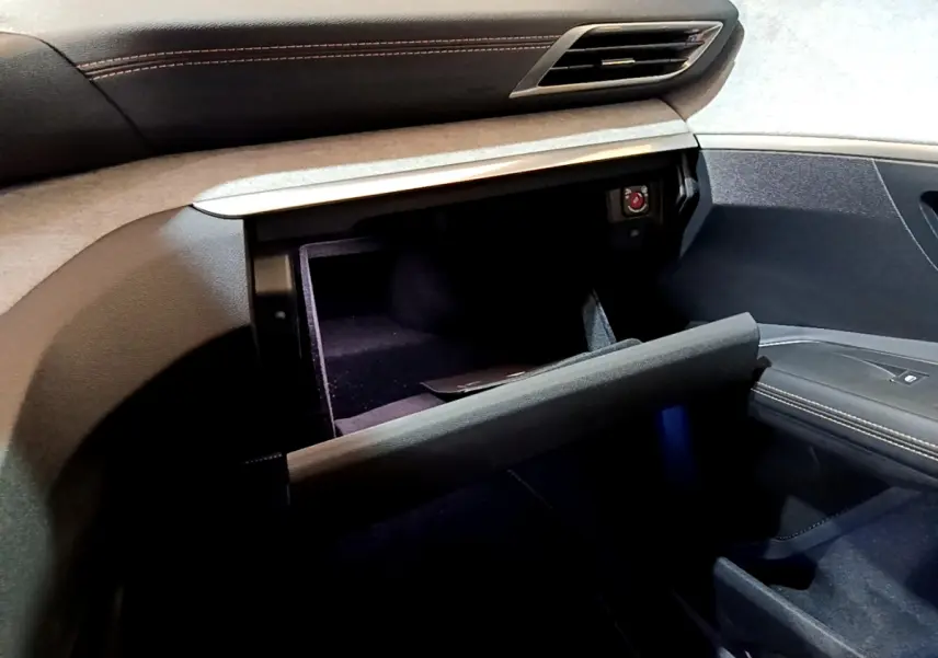 Intérieur du Peugeot 3008 GT 2023, vue côté passager sur la boîte à gants ouverte avec finition noire et surpiqûres.