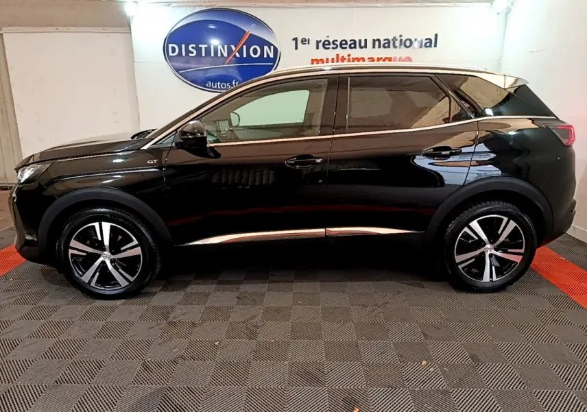 Profil côté gauche d'un Peugeot 3008 GT noir 2023 avec jantes alliage et vitres teintées en intérieur showroom.