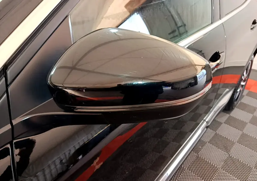 Rétroviseur côté gauche noir brillant du Peugeot 3008 GT 2023 avec carrosserie noire et jante visible en arrière-plan.