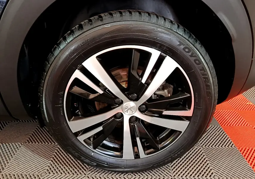 Gros plan sur la jante alliage bicolore et pneu Toyo du côté droit du Peugeot 3008 noir 2023.