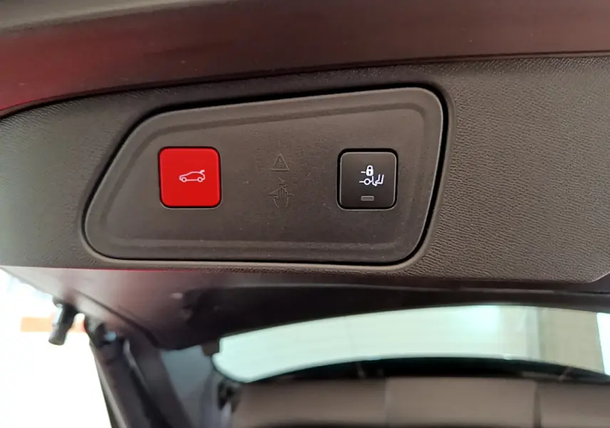Boutons de commande rouge et noir pour ouverture et verrouillage du hayon, vue intérieure arrière du Peugeot 3008 noir.