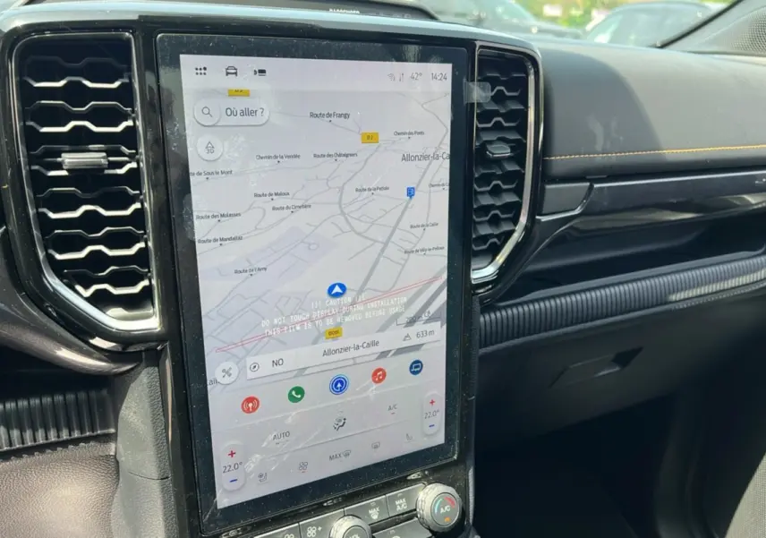 Vue rapprochée de la console centrale noire du Ford Ranger Wildtrak 2025 avec écran tactile GPS vertical allumé.