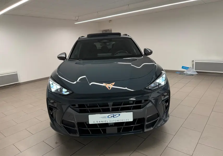 Vue avant d'une CUPRA TERRAMAR Bleu Fjord avec toit ouvrant panoramique et jantes cuivrées en intérieur showroom.