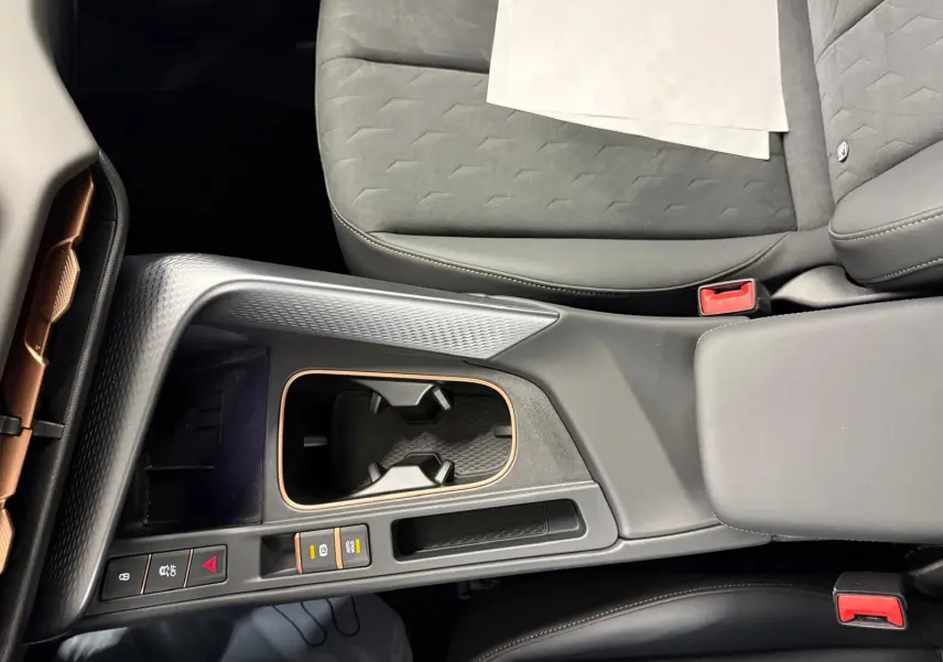 Vue plongeante sur la console centrale et les sièges avant gris du CUPRA TERRAMAR 1.5 eHybrid avec surpiqûres cuivrées.