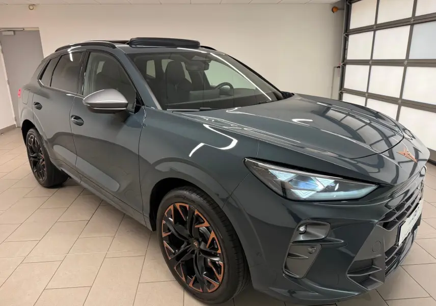 Vue 3/4 avant du CUPRA TERRAMAR 2025 bleu Fjord avec jantes cuivrées et toit ouvrant panoramique en intérieur.