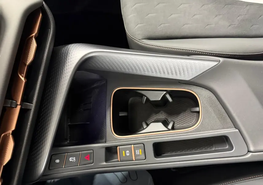 Gros plan sur la console centrale noire avec inserts cuivrés et porte-gobelets du CUPRA TERRAMAR 2025.