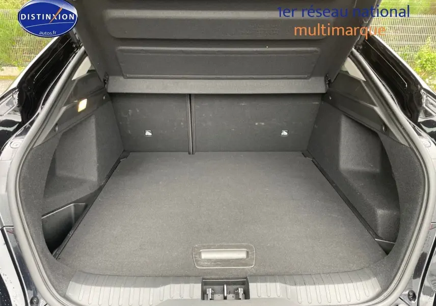 Coffre ouvert d'un Renault Arkana noir métal 2023, vue arrière montrant l'espace de chargement vide et bien fini.