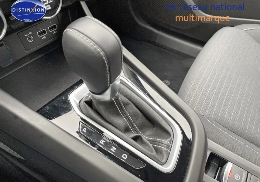 Le levier de vitesses automatique en cuir noir avec surpiqûres blanches dans l'habitacle du Renault Arkana 2023.