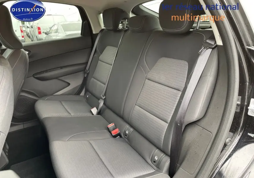 Vue côté droit de l'intérieur arrière du Renault Arkana noir métal 2023, sièges tissu gris avec ceintures visibles.