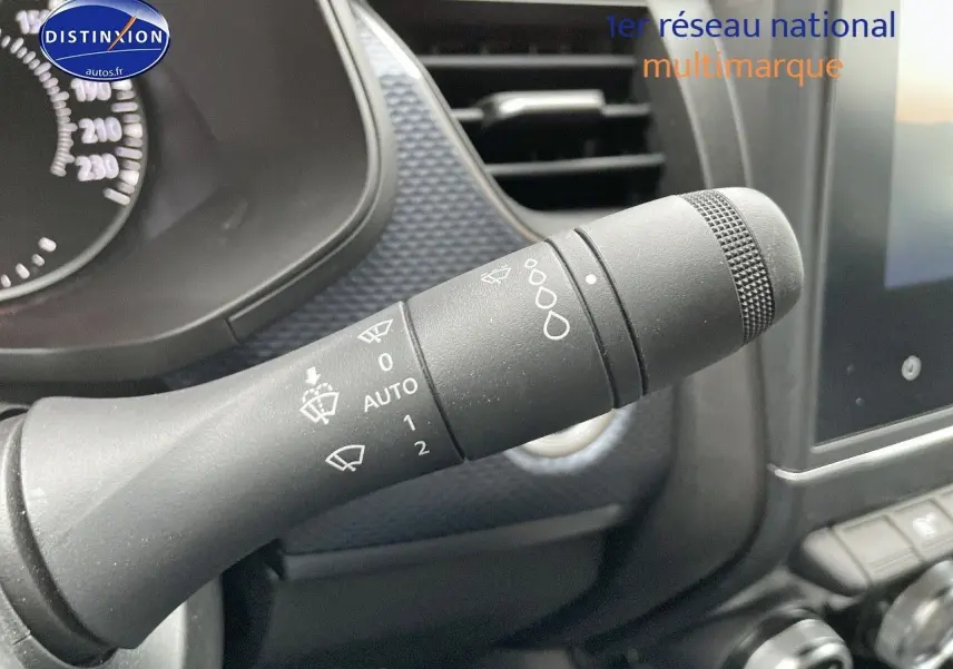 Gros plan sur la commande d'essuie-glace du Renault Arkana noir métal, avec tableau de bord et écran tactile en arrière-plan.