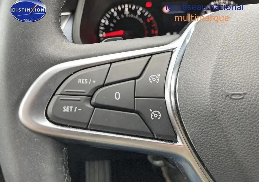 Gros plan sur les commandes de régulateur de vitesse au volant cuir noir du Renault Arkana 2023 finition Evolution.