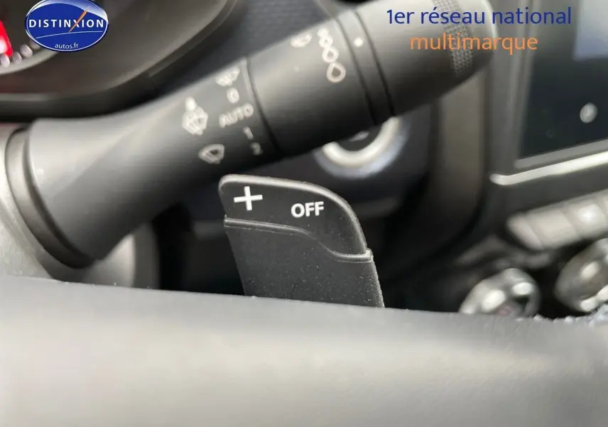 Gros plan sur la palette de changement de vitesse + OFF au volant d'un Renault Arkana noir métal, intérieur moderne.