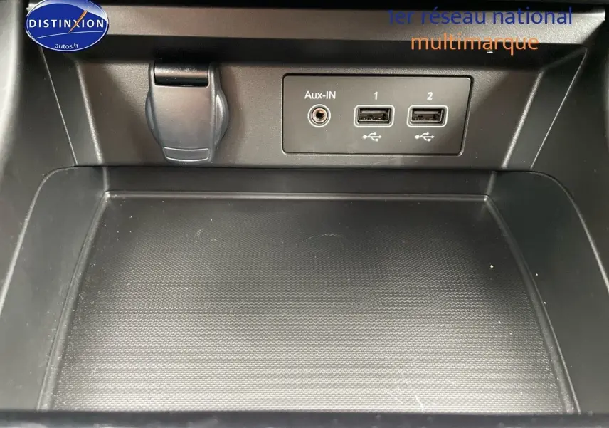 Gros plan sur la console centrale noire du Renault Arkana 2023 avec prises USB et entrée Aux-In visibles.