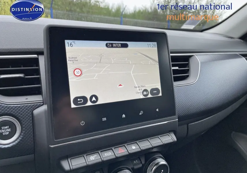 Écran tactile central avec navigation, tableau de bord et console d'une Renault Arkana noir métal vue de l'intérieur côté passager.