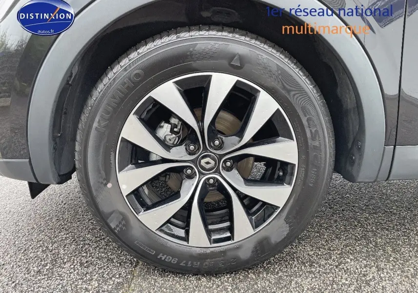 Gros plan sur la roue avant gauche noire métal du Renault Arkana Mild Hybrid 140ch avec jante bi-ton distinctive.