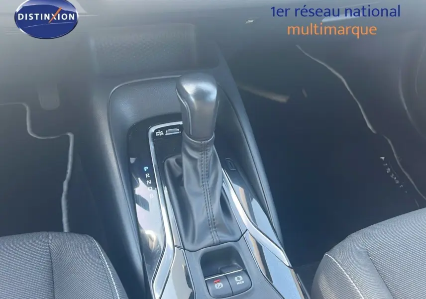 Le levier de vitesse automatique en cuir noir de la Toyota Corolla hybride 2023, vue intérieure centrée sur la console centrale.