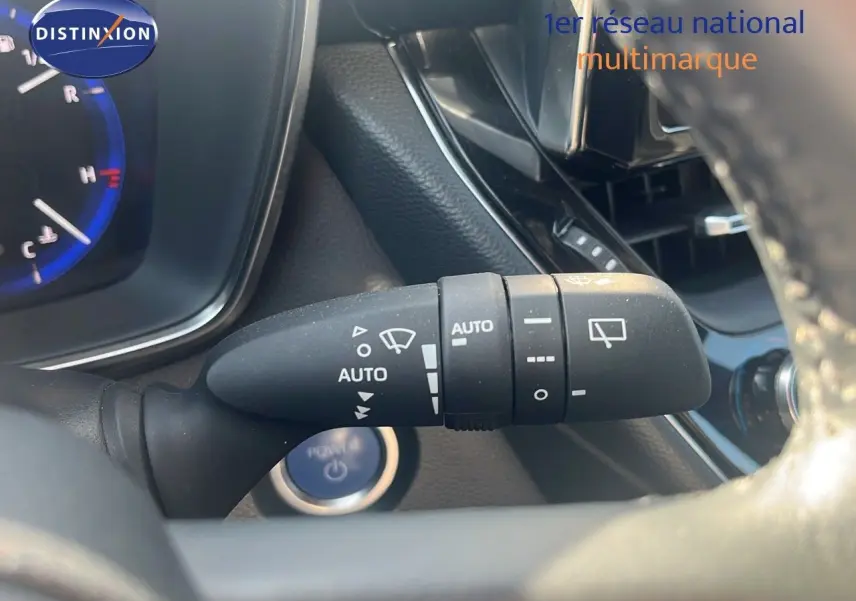 Gros plan sur la commande d’essuie-glace automatique à droite du volant dans l’habitacle d’une Toyota Corolla blanche 2023.