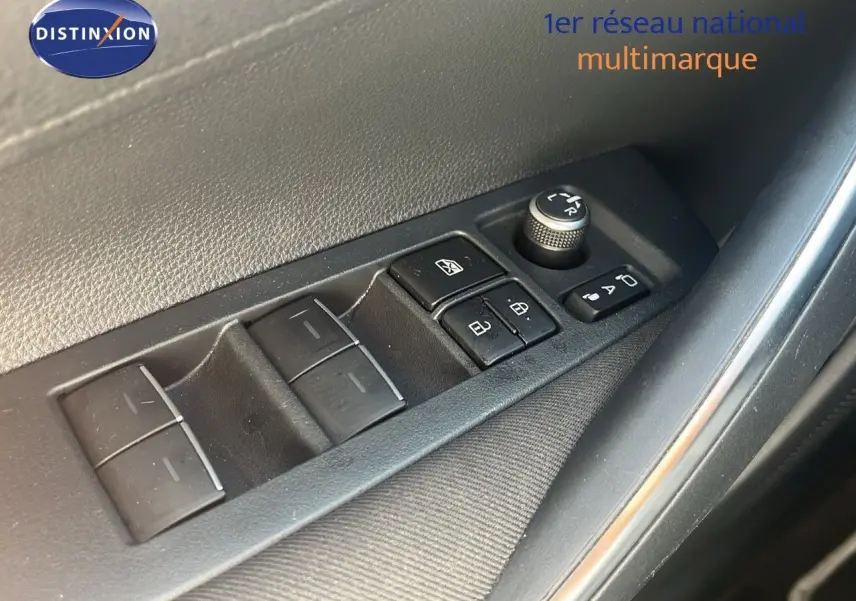 Gros plan sur les commandes électriques de lève-vitres et rétroviseurs côté conducteur d'une Toyota Corolla blanche 2023.