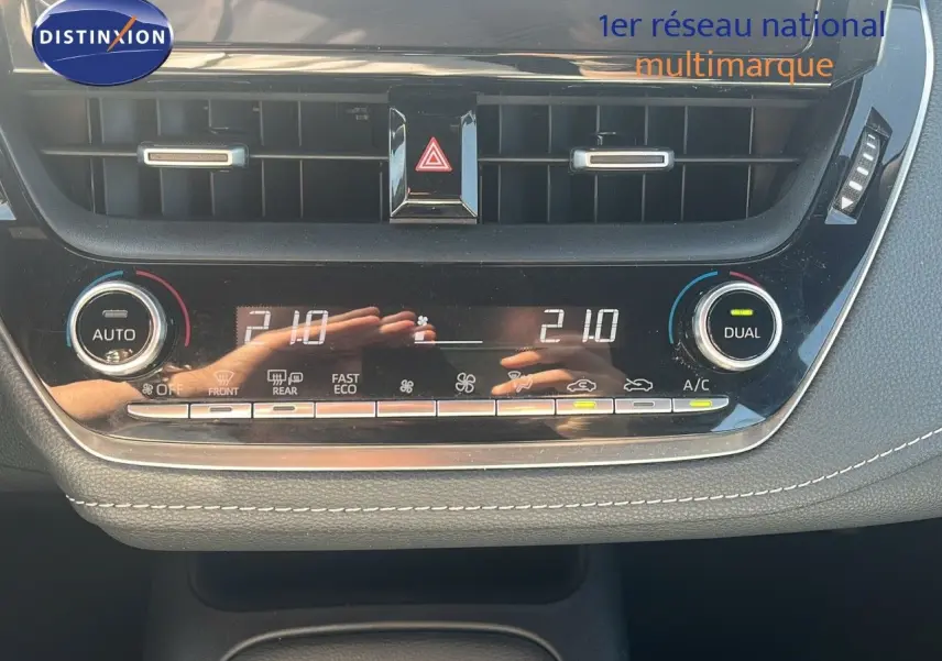 Panneau de commande de climatisation automatique de la Toyota Corolla blanche 2023, affichant 21°C en mode dual.