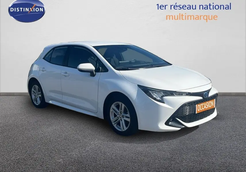 Toyota Corolla 1.8 HSD blanc pur vue 3/4 avant droit avec calandre noire et jantes alliage 16 pouces