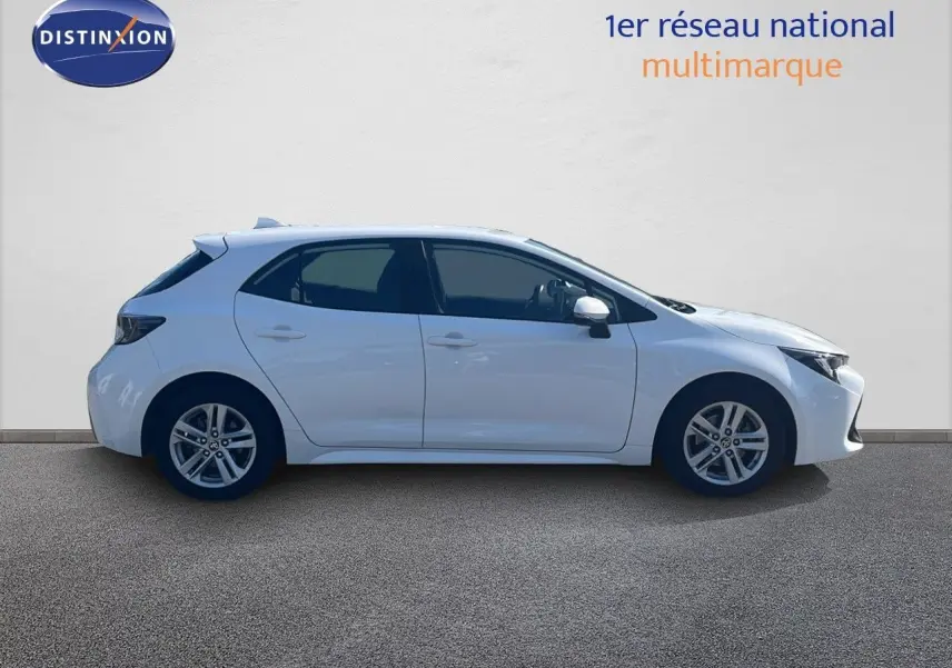 Profil droit d'une Toyota Corolla 1.8 HSD 122CH CVT Dynamic blanche pure, cinq portes, sur fond neutre.