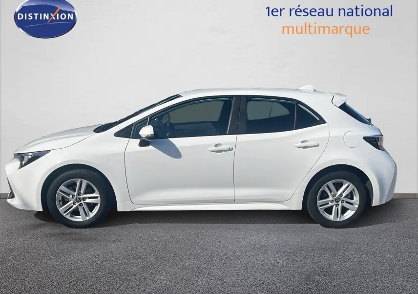 Profil droit d'une Toyota Corolla blanche pure hybride 2023 avec jantes alliage et carrosserie compacte cinq portes.