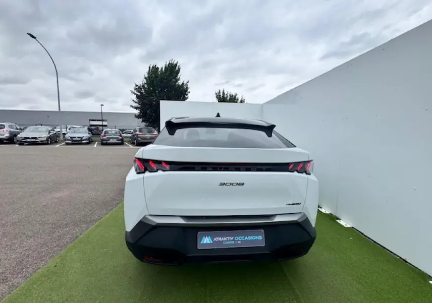 Vue arrière d'un Peugeot 3008 blanc nacré avec toit noir, feux arrière à griffes LED et bandeau noir laqué.