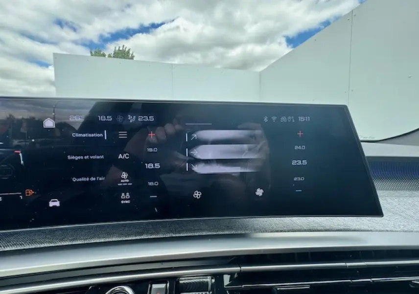 Écran tactile panoramique du tableau de bord du Peugeot 3008 blanc nacré 2024 affichant la climatisation.