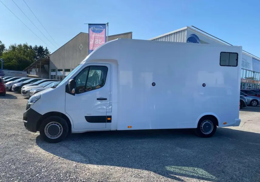 Profil côté gauche d'un Opel Movano Fourgon blanc 2021 avec capucine et petite fenêtre arrière.