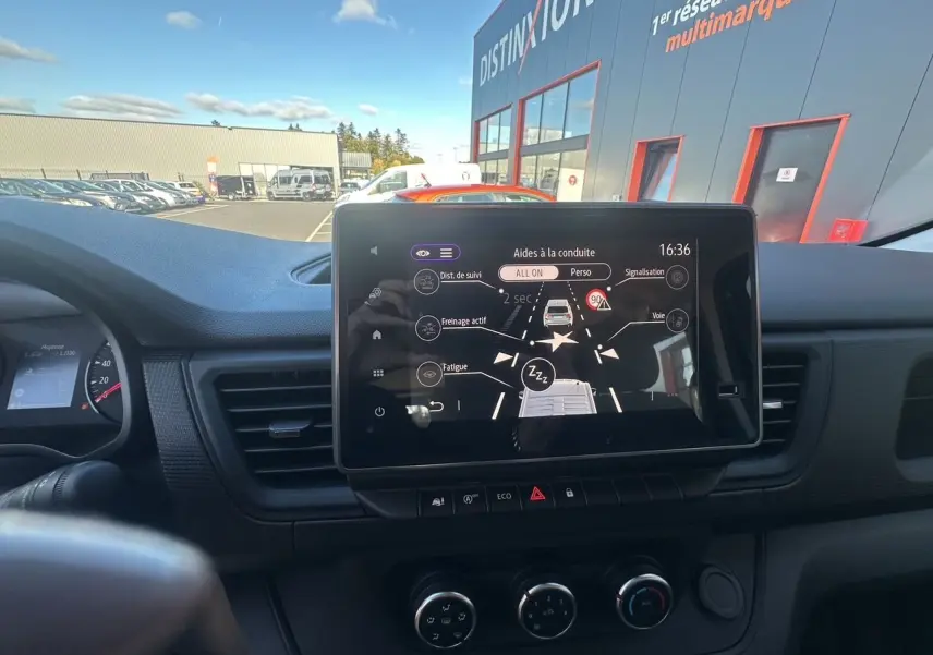 Écran tactile central du tableau de bord du Renault Trafic Combi gris, avec affichage des aides à la conduite.