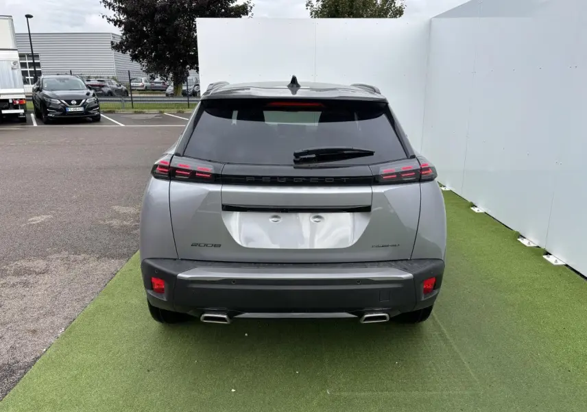 Vue arrière d'un Peugeot 2008 gris Artense avec toit noir, feux LED 3 griffes et double sortie d'échappement chromée.