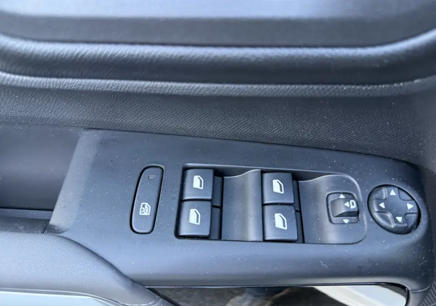 Gros plan sur les commandes des vitres électriques et rétroviseurs côté gauche d'un Citroën C5 Aircross blanc nacré 2021.
