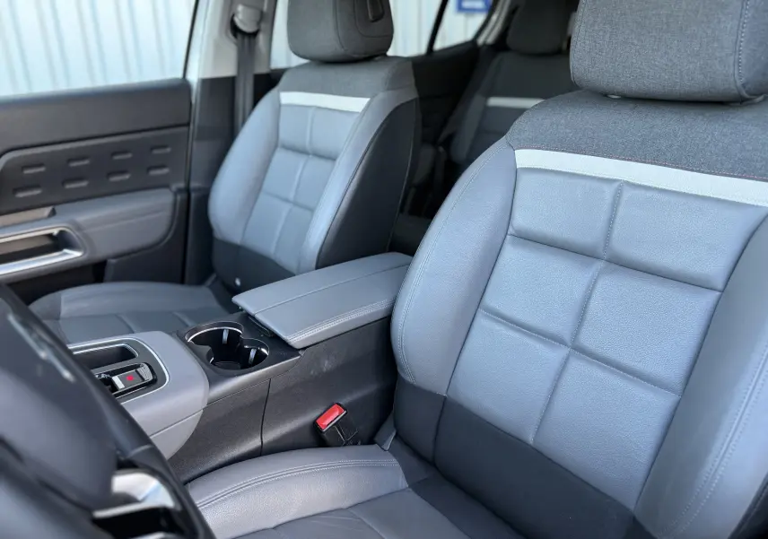 Vue rapprochée des sièges avant en cuir gris et tissu sur le côté gauche du Citroën C5 Aircross 2021 blanc nacré.