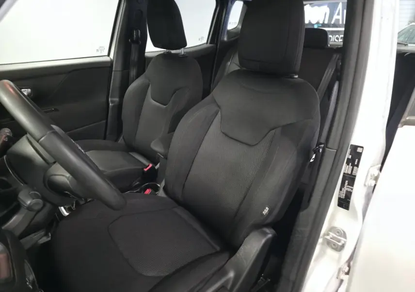 Intérieur du Jeep Renegade 2018 blanc, vue côté gauche sur les sièges avant noirs avec appuie-têtes réglables.