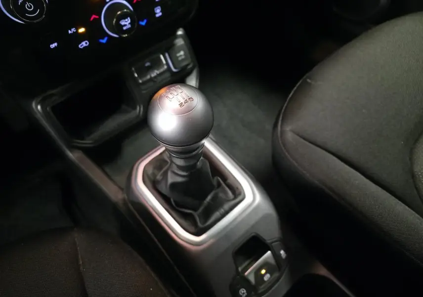 Le levier de vitesses manuel argenté du Jeep Renegade 2018, entouré de la console centrale et sièges noirs.