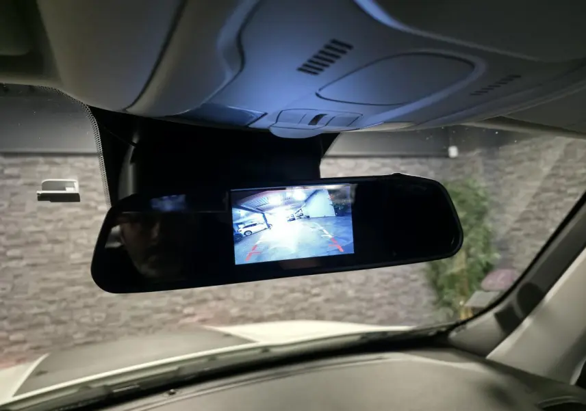 Vue intérieure du rétroviseur central numérique du Jeep Renegade blanc, affichant la caméra de recul en fonctionnement.