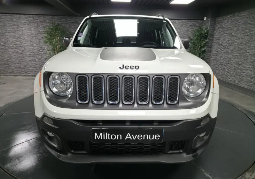 Vue frontale d'un Jeep Renegade blanc avec calandre gris clair et jantes noires cinq branches.