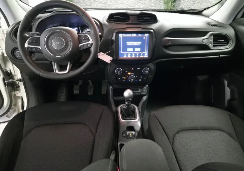 Vue intérieure avant du Jeep Renegade 2018 avec volant cuir multifonctions et boîte manuelle au levier chromé.