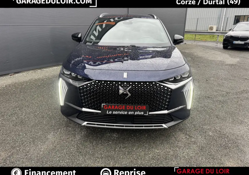 Vue avant d'un DS7 Crossback Bleu avec calandre diamantée et feux LED verticaux allumés sous la pluie