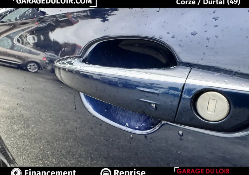 Poignée de porte côté droit bleu métallisé du DS7 Crossback 2024 avec traces de pluie et serrure intégrée.