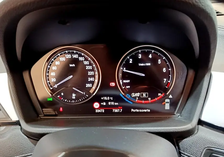 Vue rapprochée du tableau de bord numérique du BMW X2 sDrive18i 2023, affichant vitesse et compte-tours.