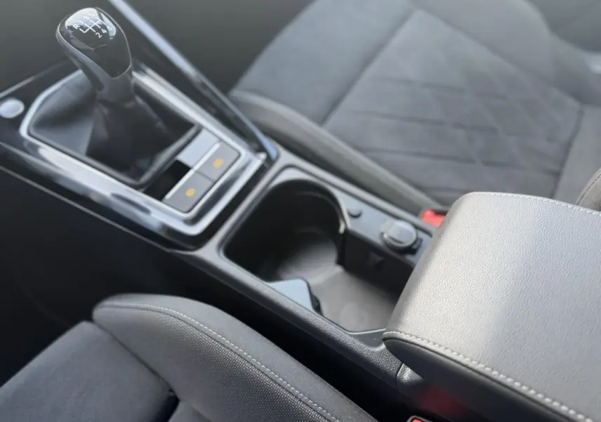 Gros plan sur la console centrale et levier de vitesses manuel de la Volkswagen Golf VIII 1.5 TSI Style 2024 avec sellerie microfleece noire.