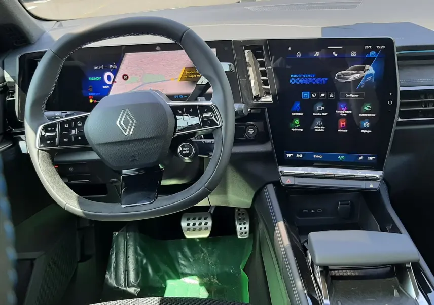 Vue intérieure du poste de conduite du Renault Espace VI gris schiste, avec volant multifonction et grand écran tactile central.