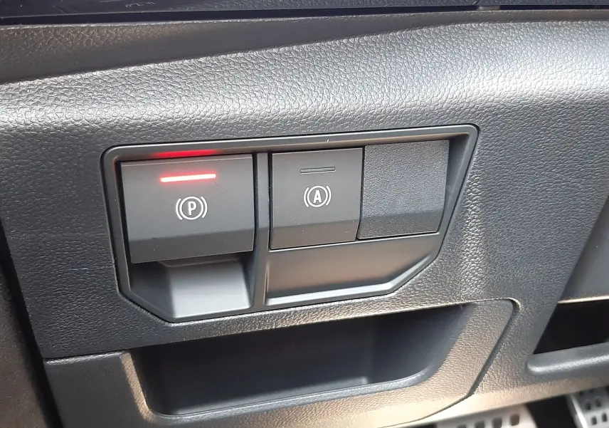 Gros plan sur les commandes de frein à main électronique et arrêt automatique du moteur du Renault Espace VI gris schiste.