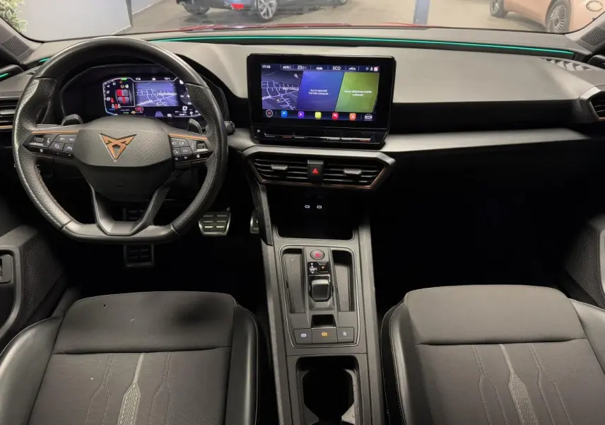 Intérieur avant du CUPRA Leon Sportstourer 1.4 e-Hybrid 2021, tableau de bord noir avec écran tactile central et volant multifonction.